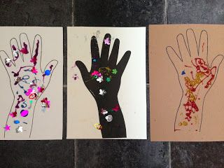 three handprints are displayed on the floor with colored paper and beads in them