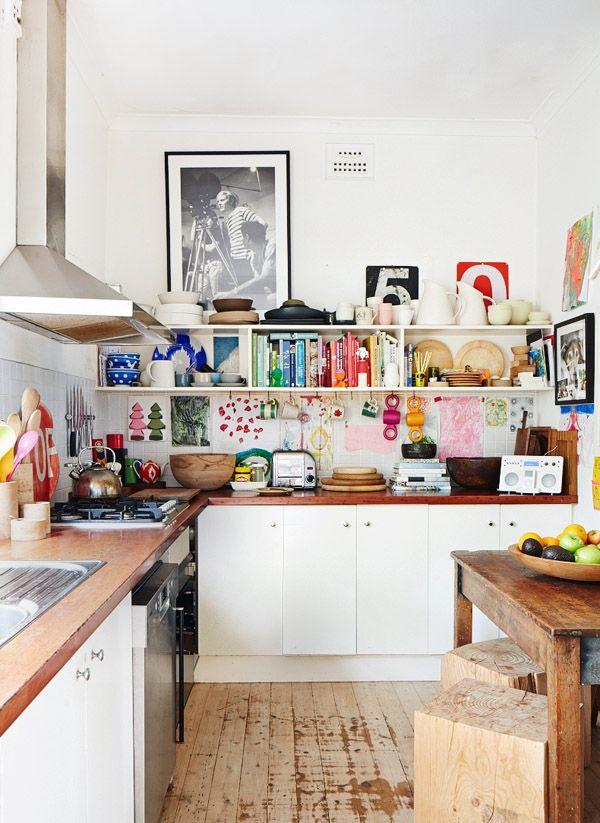 a kitchen filled with lots of clutter and cooking utensils on top of wooden counter tops