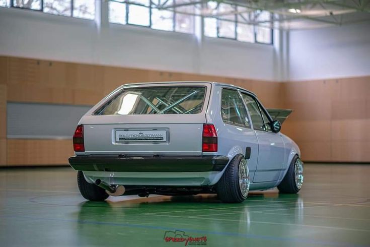 an old white car parked in a garage