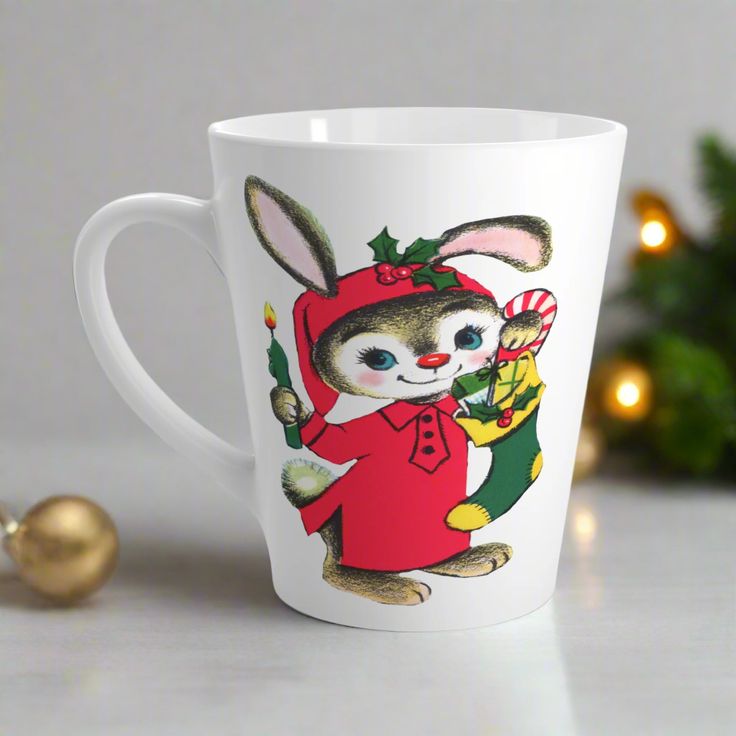 a white coffee cup with an image of a bunny holding a candy cane in it's hand