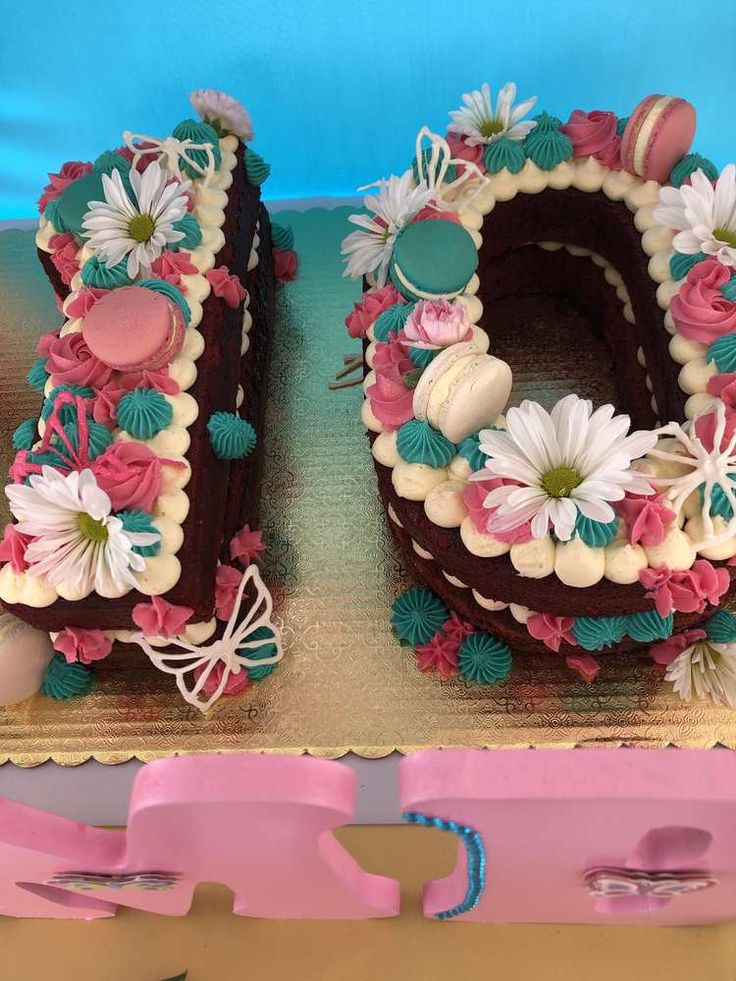 a cake shaped like the number 50 with flowers and eggs on it's sides