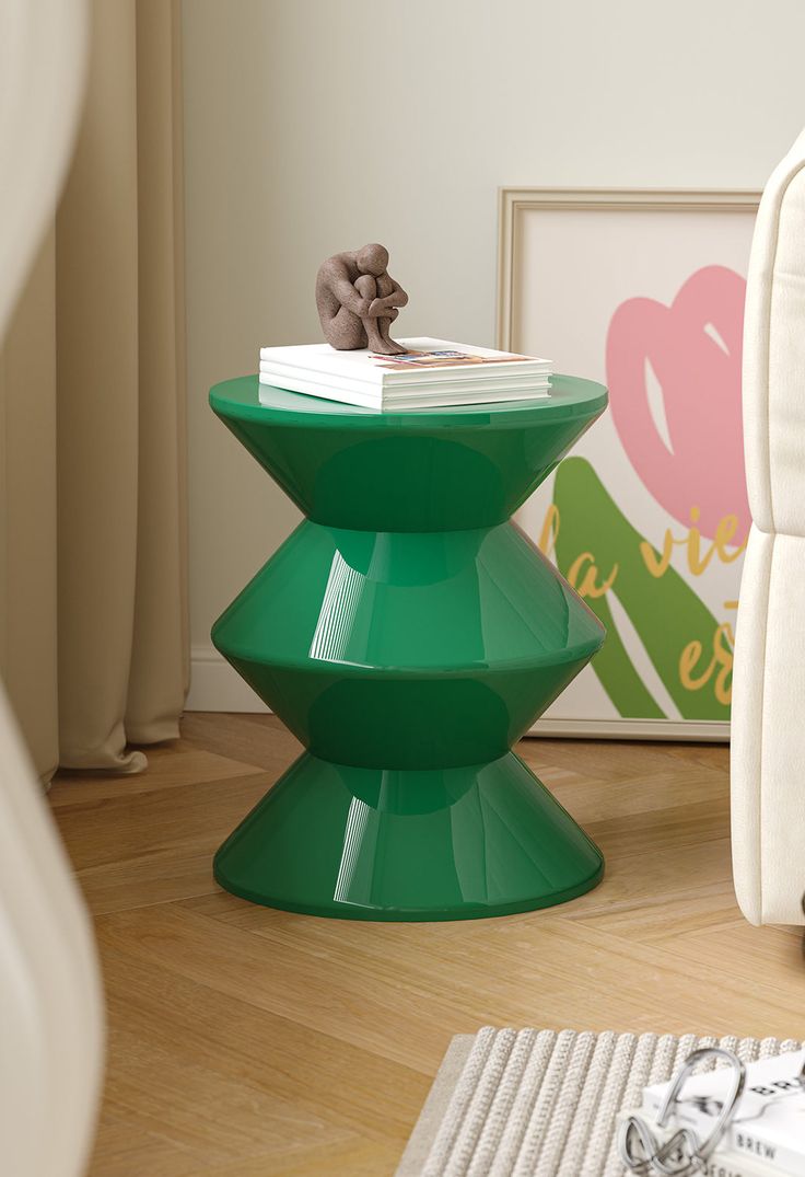 a green table sitting on top of a hard wood floor next to a white chair