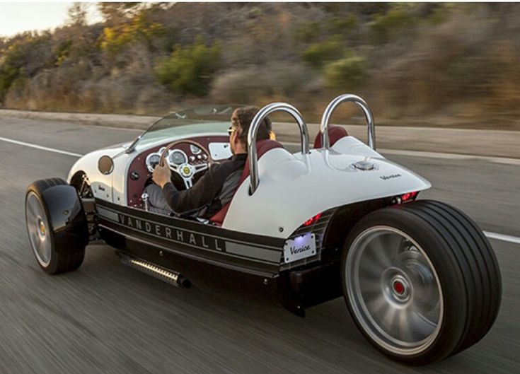 a man driving a buggy on the road with another person in it's seat