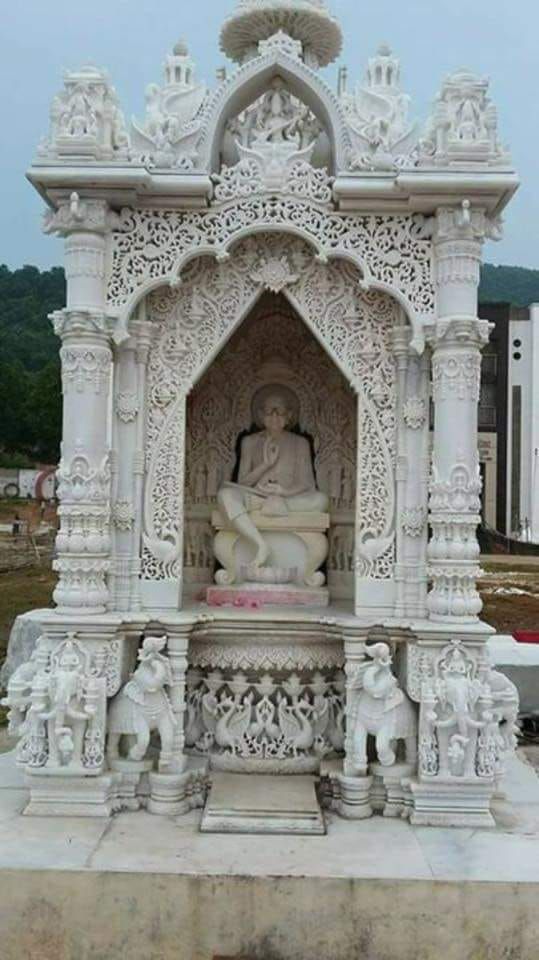 a white statue sitting on top of a cement slab