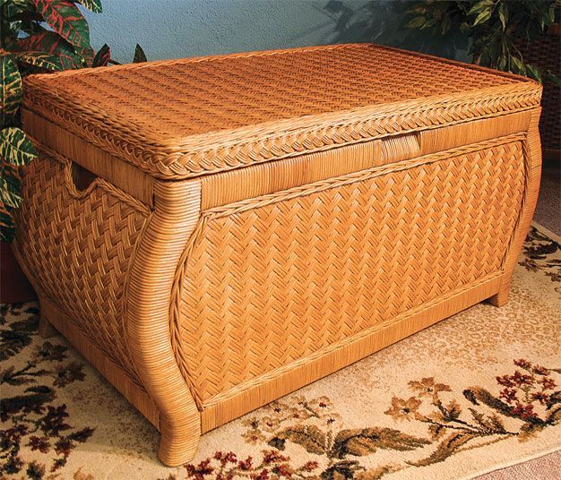 a large wooden trunk sitting on top of a carpeted floor next to potted plants