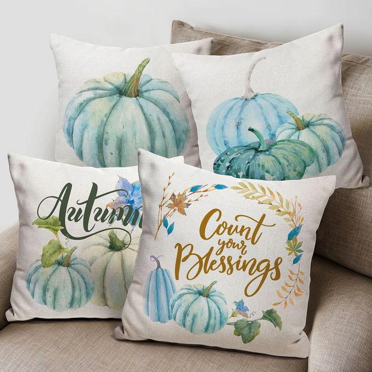 three decorative pillows with pumpkins on them