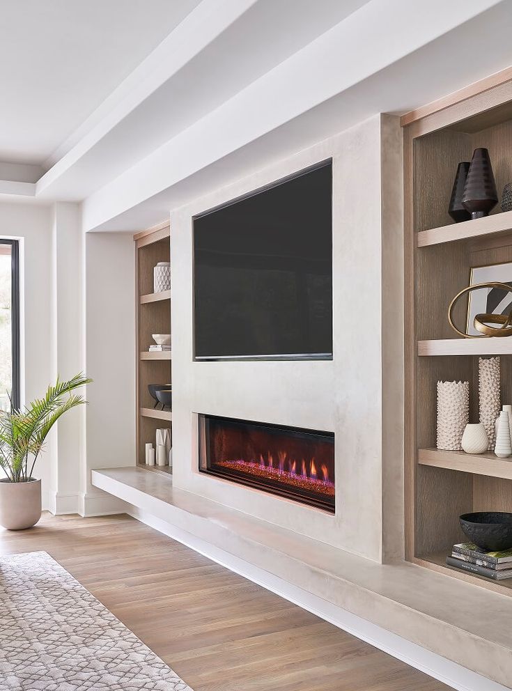 a living room filled with furniture and a flat screen tv mounted on a wall above a fire place