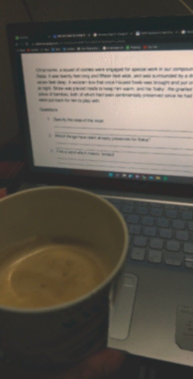 a cup of coffee sitting next to a laptop computer