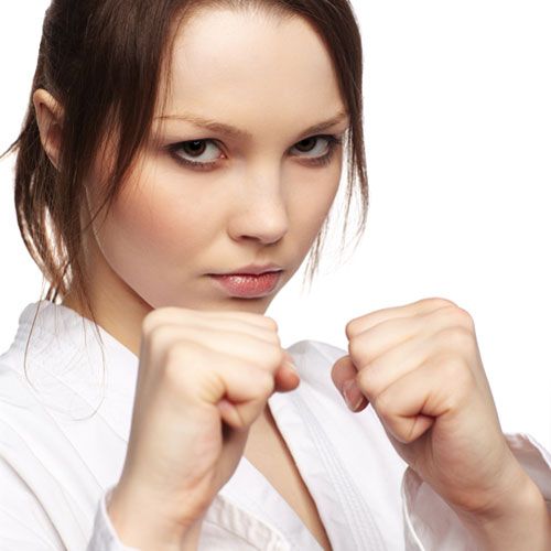 a woman in white shirt posing with her fists crossed