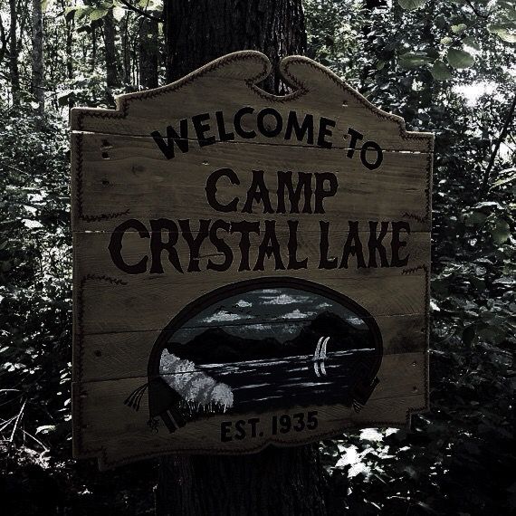 a welcome sign to camp crystal lake in the woods