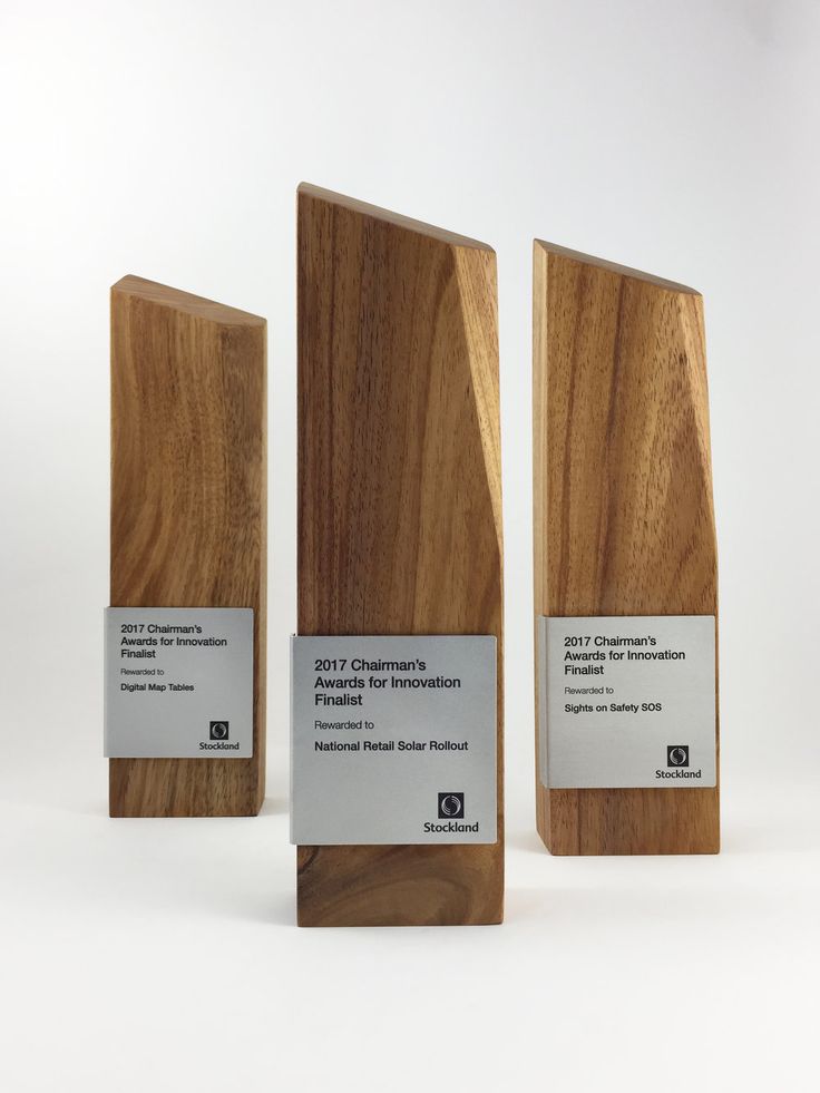 three wooden plaques with white labels on them sitting side by side in front of each other