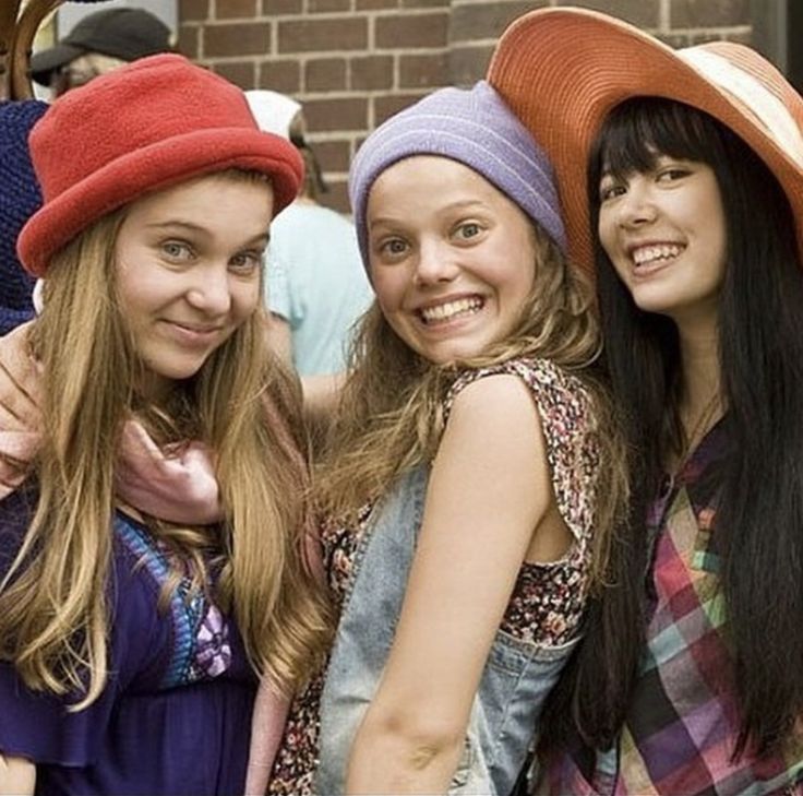 three girls are posing for the camera with hats on