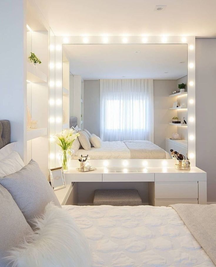 a bedroom with white furniture and lights on the wall