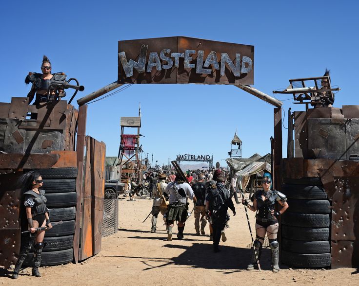 a group of people that are standing in front of some mud pots and barrels with the words wasteland on them