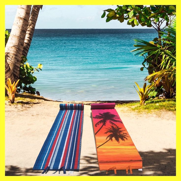 two beach towels laying on top of a sandy beach next to the ocean and palm trees