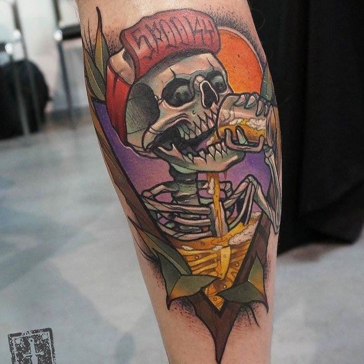 a man's leg with a colorful skull and anchor tattoo design on the calf