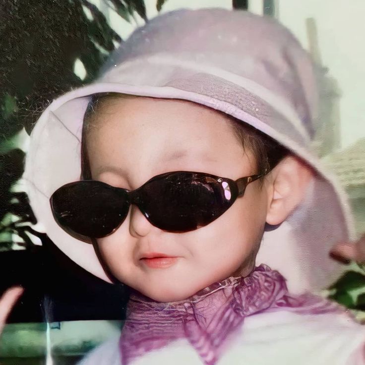 a young child wearing sunglasses and a hat