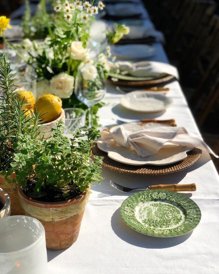 a long table with plates and flowers on it