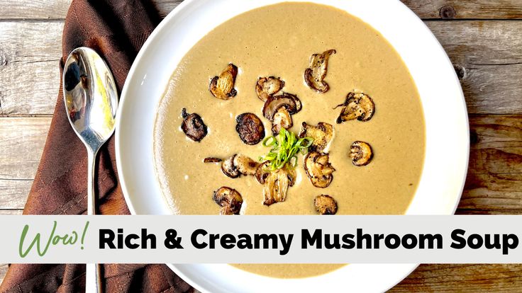 a bowl of creamy mushroom soup on top of a wooden table next to a spoon