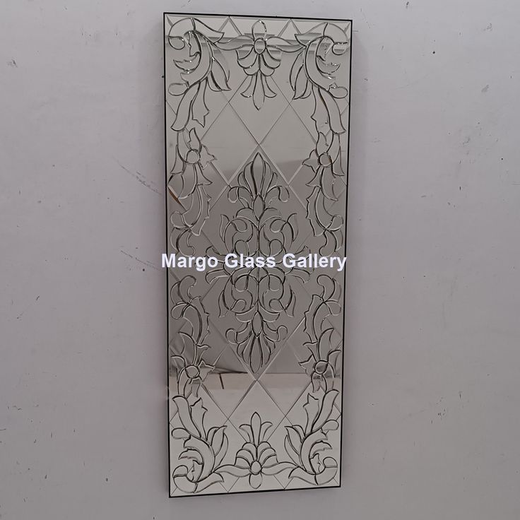 an ornate mirror hanging on the wall in front of a white wall with text reading margo glass gallery