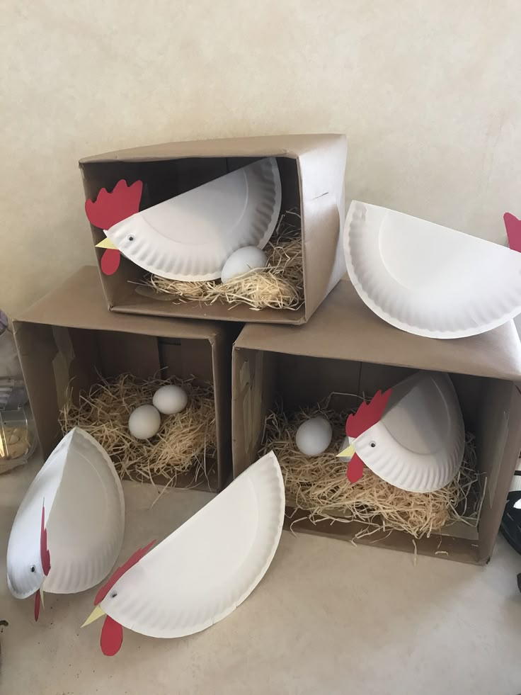 three cardboard boxes filled with paper plates and chickens