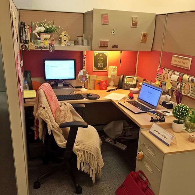 an office cubicle with two computers on the desk