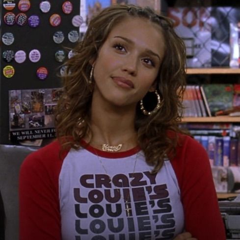 a woman standing in front of a bookshelf wearing a t - shirt with the words crazy louis's liquories on it