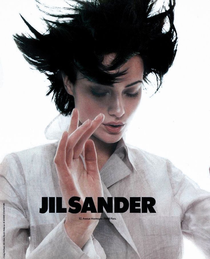 a woman with her hair blowing in the wind while wearing a white shirt and tie