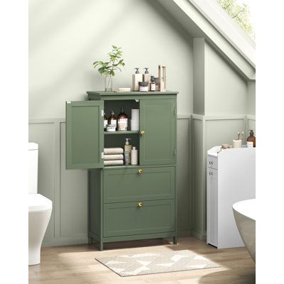 a green cabinet in the corner of a bathroom