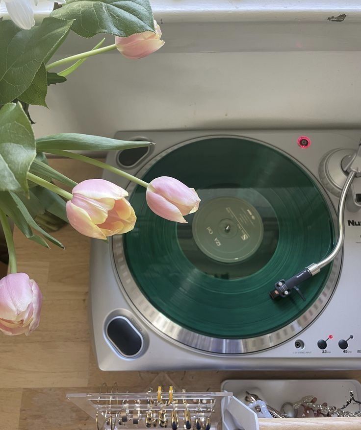 a record player with flowers in front of it