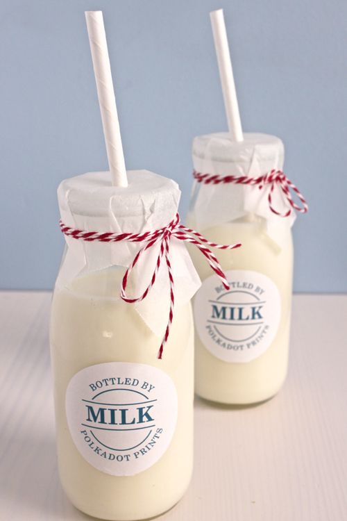 two jars filled with milk sitting on top of a table