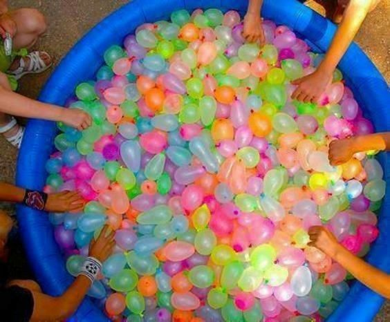 several children are playing in an inflatable ball pit