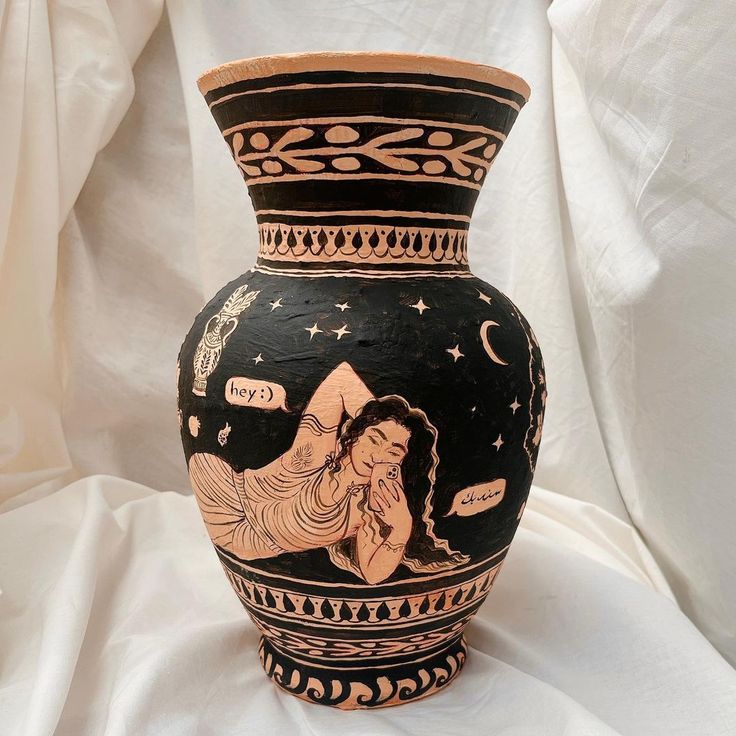 a black and white vase with an image of a woman on the side, surrounded by stars