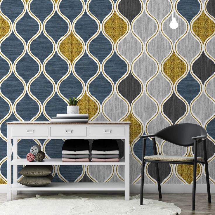 a white table sitting in front of a wall with a blue and yellow pattern on it