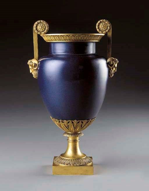 a blue and gold vase sitting on top of a table