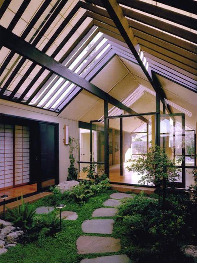 the inside of a house with stone walkways and green grass in front of it