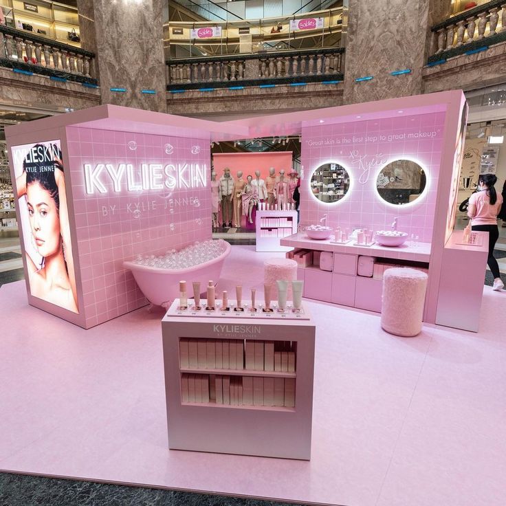 a pink display in the middle of a mall filled with cosmetics and personal care products