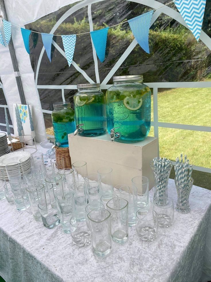 there are many glasses and jars on the table