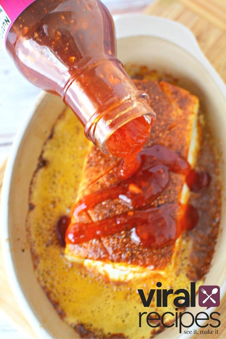 a person pouring ketchup onto a piece of bread