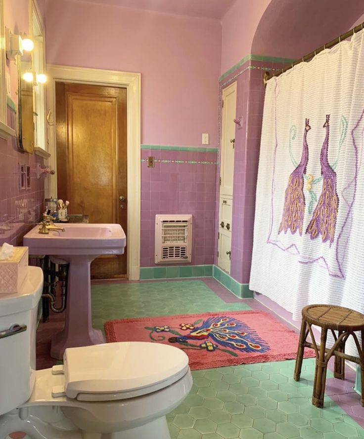 a bathroom with pink walls and green flooring has a rug on the floor next to the toilet