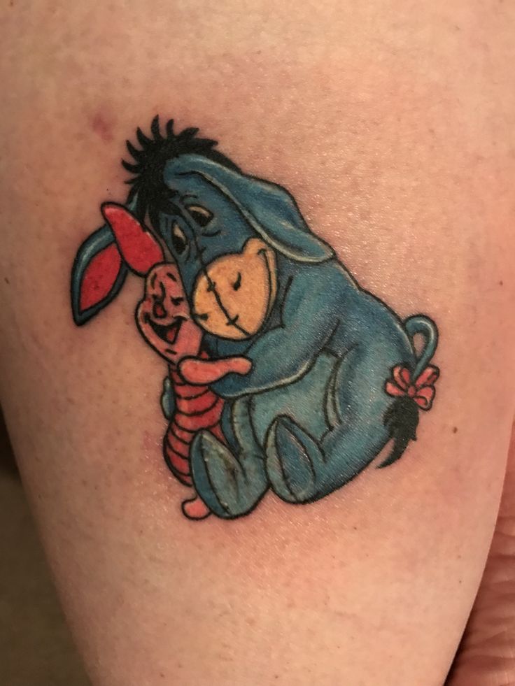 a tattoo on the leg of a person with winnie the pooh and piggy