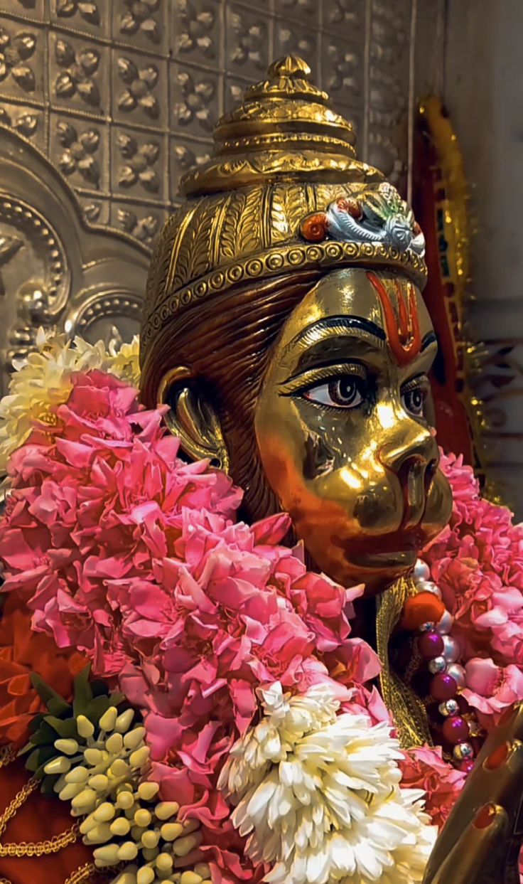 a close up of a statue with flowers around it