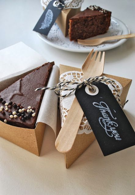 two pieces of chocolate cake in boxes on a table