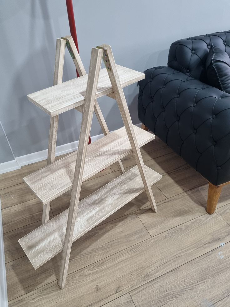 a wooden table sitting on top of a hard wood floor next to a blue couch