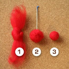 three balls of yarn are next to two pins and needles on the cork notice board