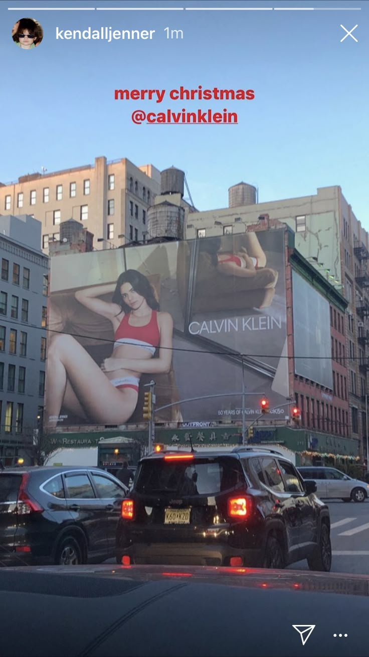 an advertisement on the side of a building in new york city, with cars driving down the street