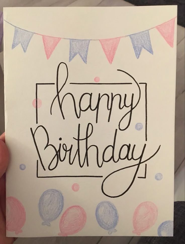 a hand holding up a birthday card with the words happy birthday written in black ink