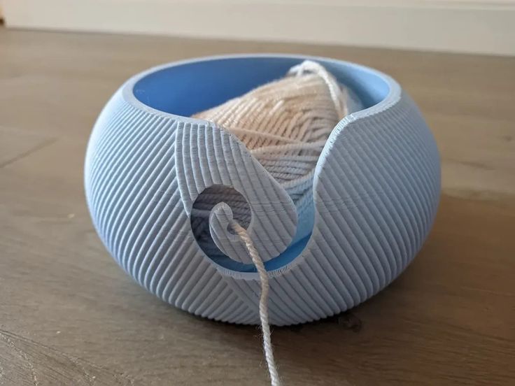 a ball of yarn sitting on top of a wooden table next to a string wrapped around it