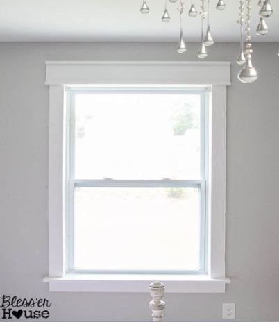 a white window with chandelier hanging from it's side in a room