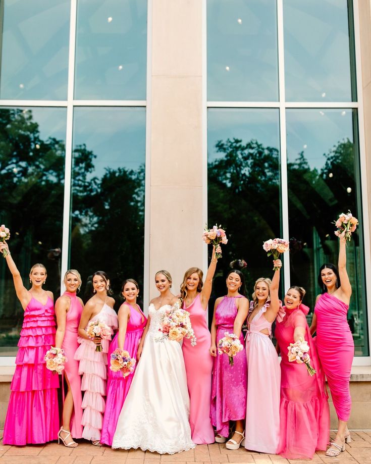 a group of women standing next to each other in front of a building with windows